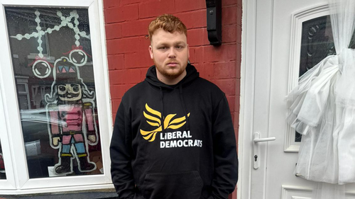 Connor Stallard - Lib Dem stood infront of a door