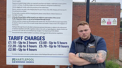 Connor Stallard with a Parking Charges board in Hartlepool town centre